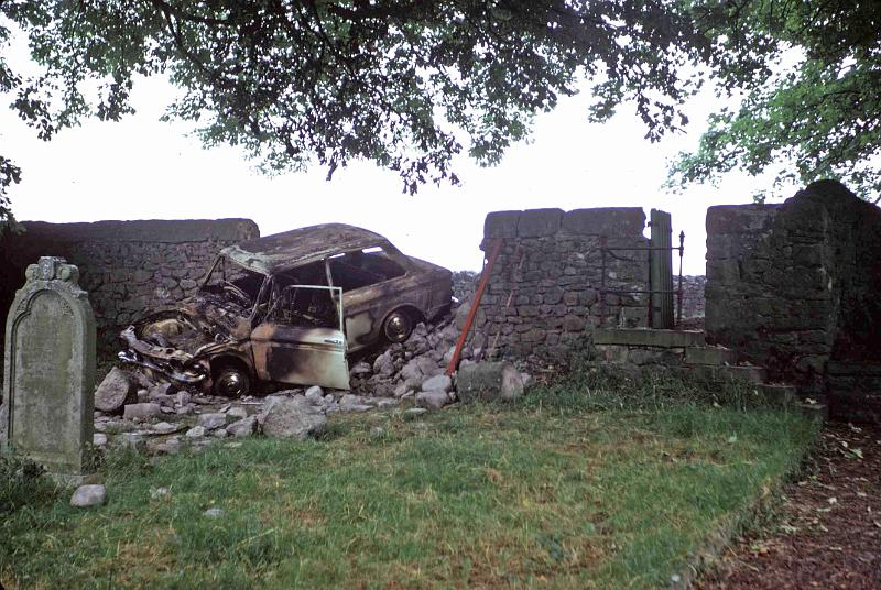 Car in Churchyard 1971.jpg - Wrecked car through the churchyard wall - September 1971.